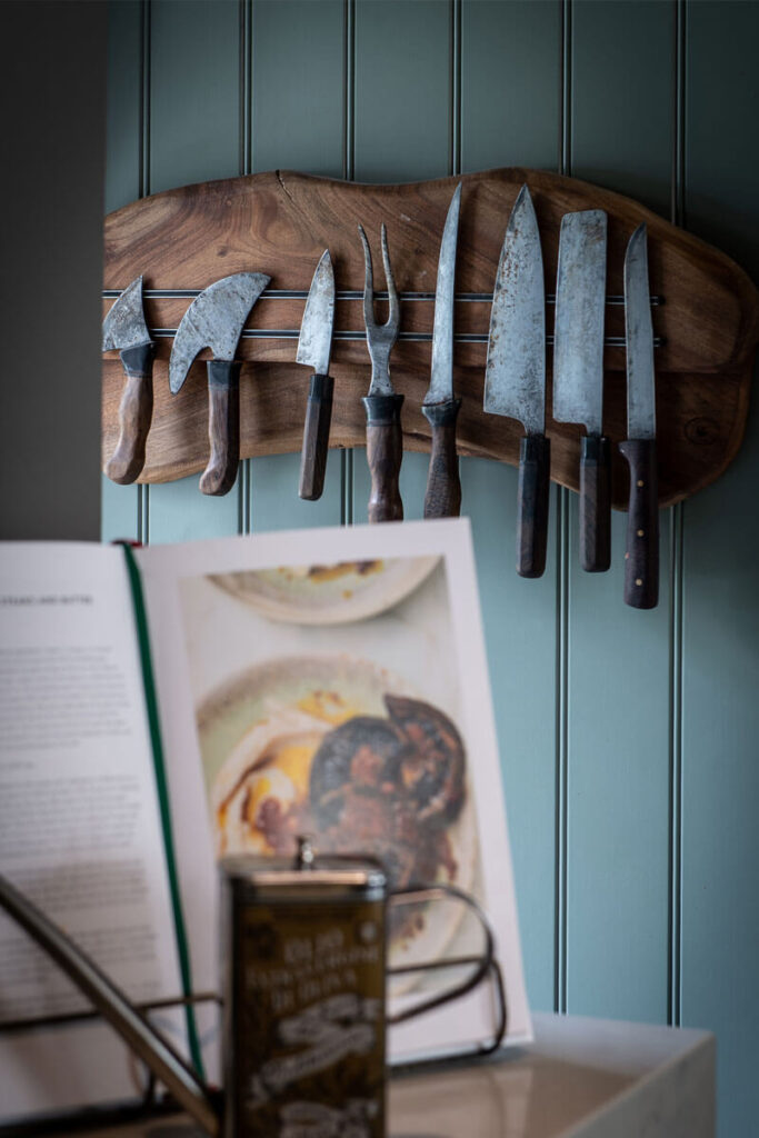 A bespoke wooden knife rack in a sage green kitchen