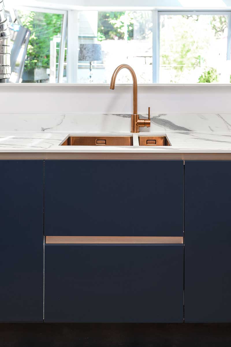 Navy blue kitchen with copper sink and tap